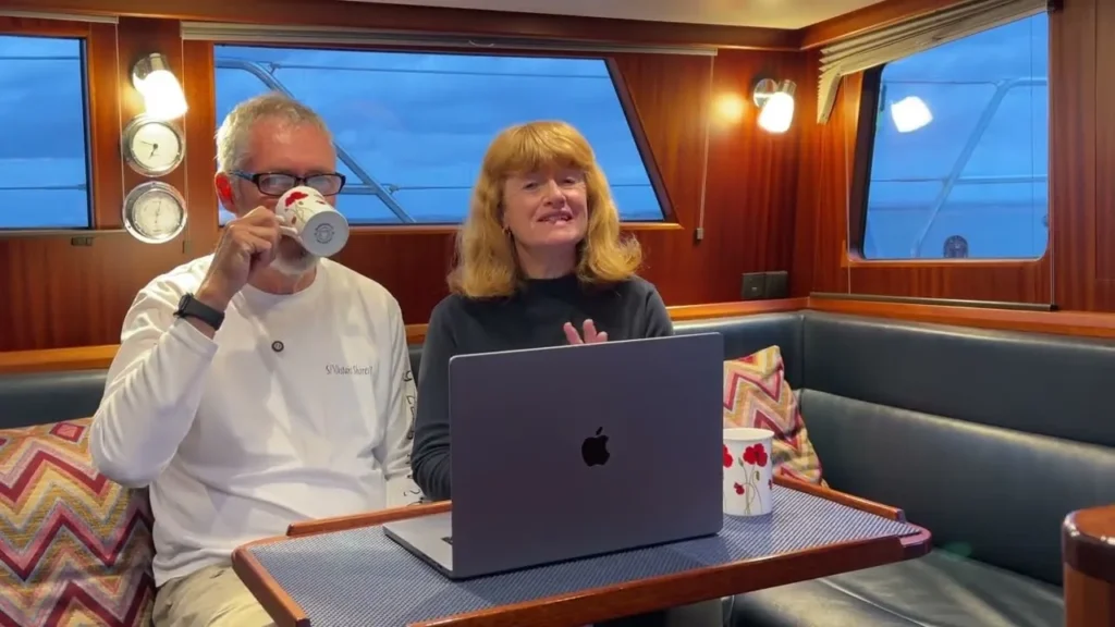 Paul and Sheryl of Distant Shores sitting in their sailboat cabin