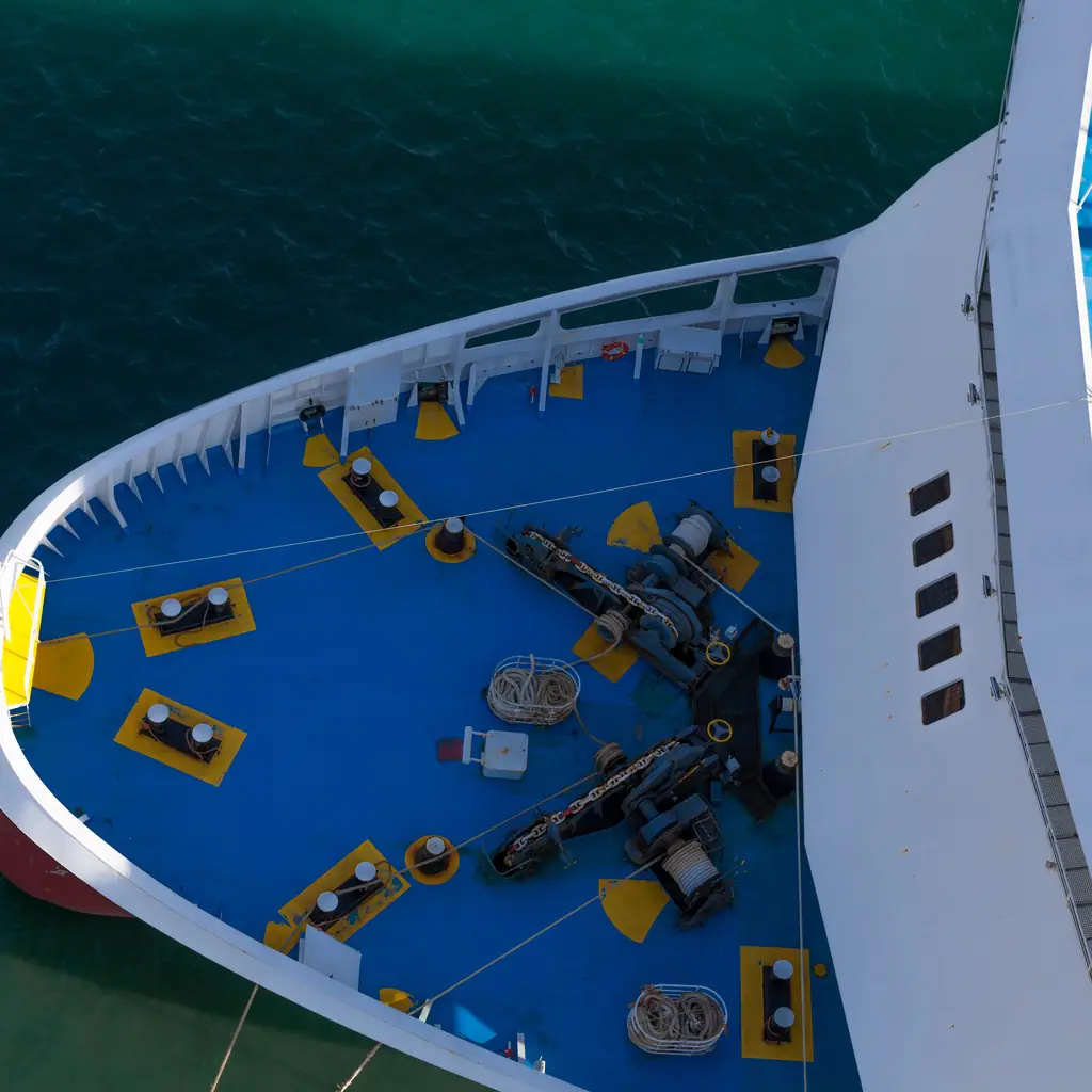 The bow and anchor of a cruise ship in early morning light