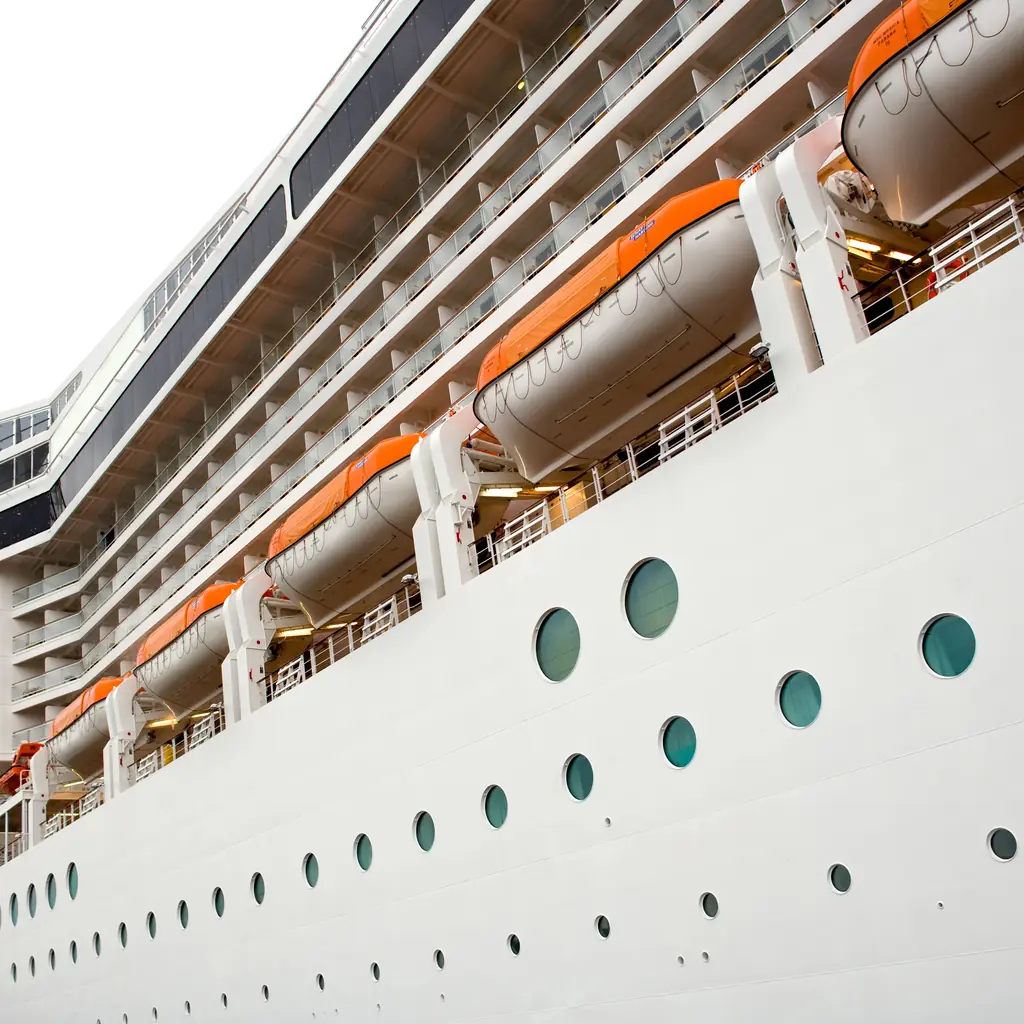 An orange lifeboat blocking part of the view from a cruise cabin balcony