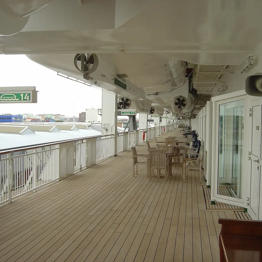 A covered promenade deck lined with cabin doors on a cruise ship