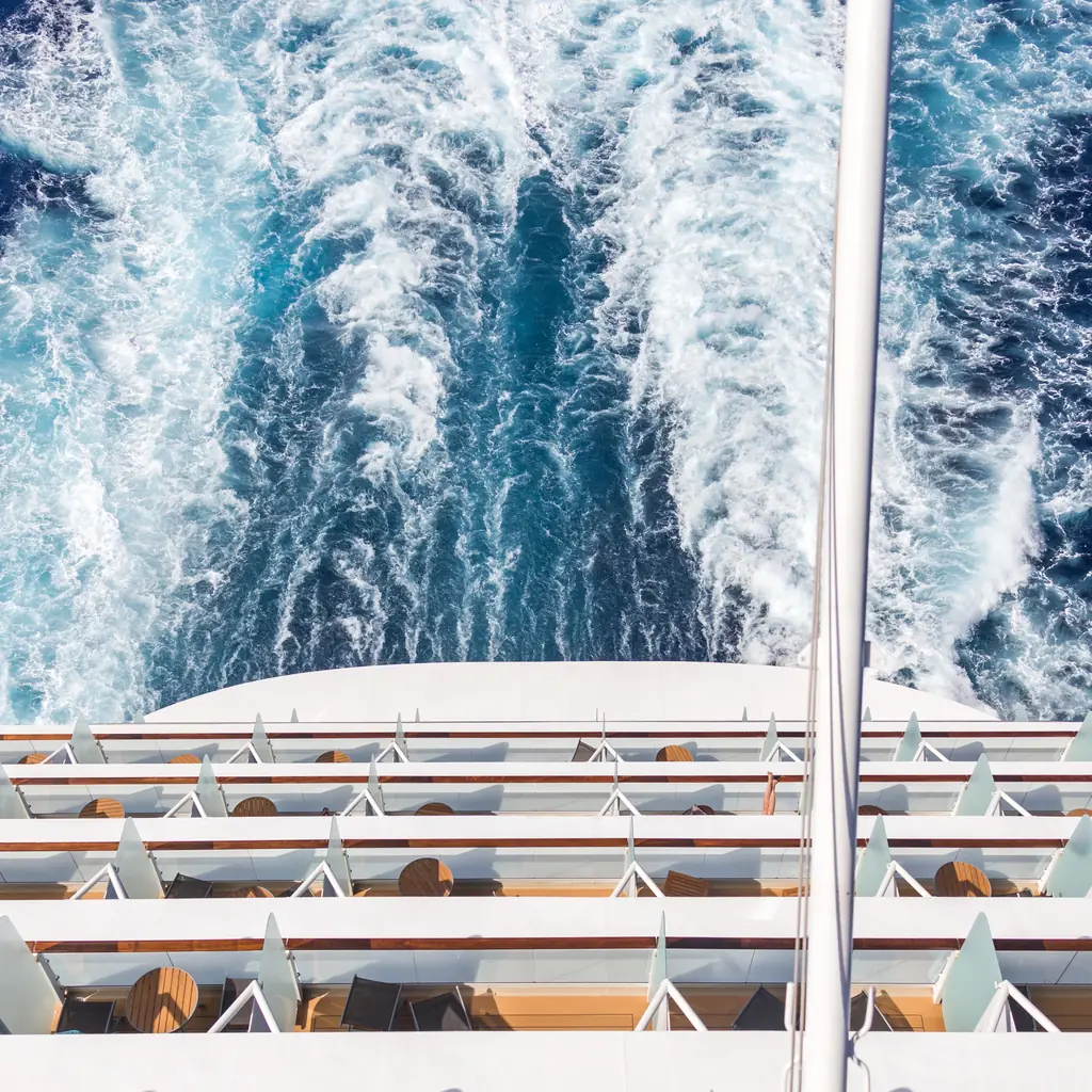 Aft corner balconies on the stern of a cruise ship above its wake