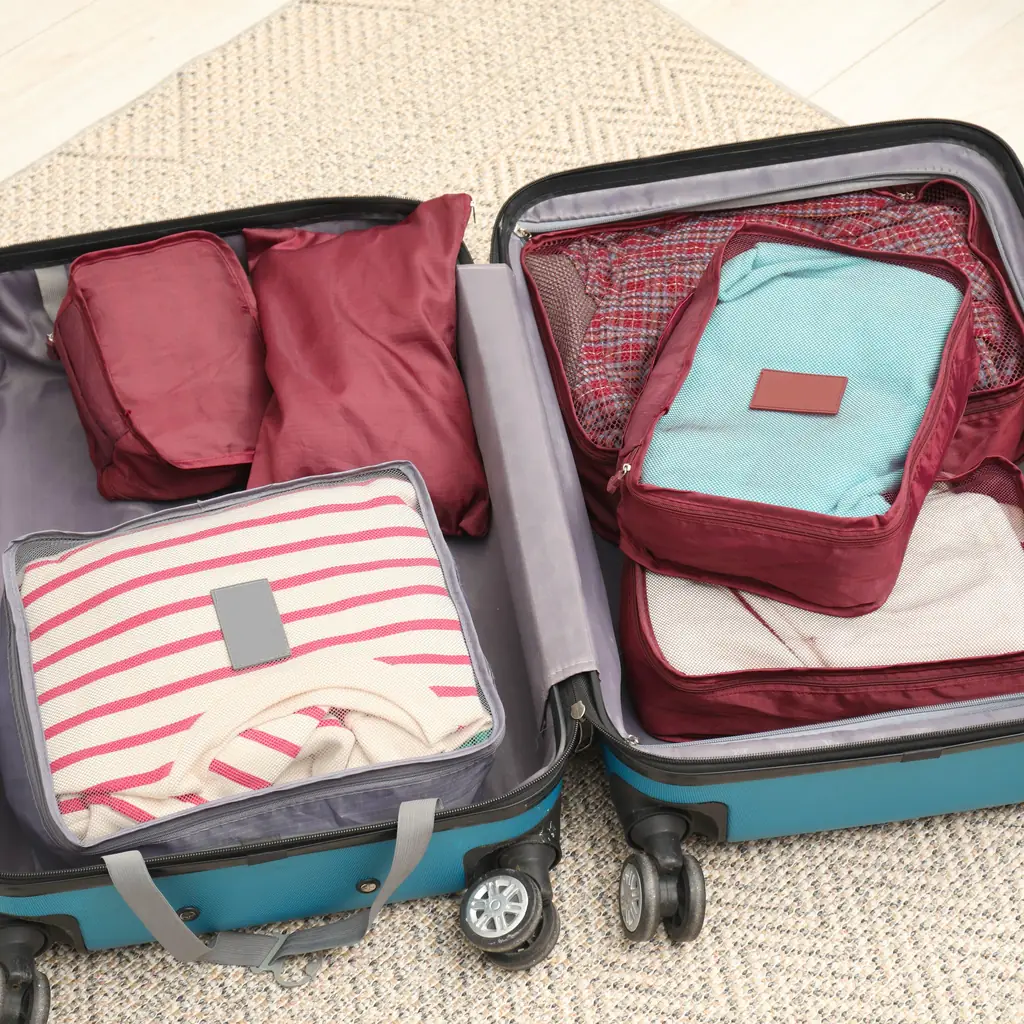 An open suitcase packed with mesh-top packing cubes