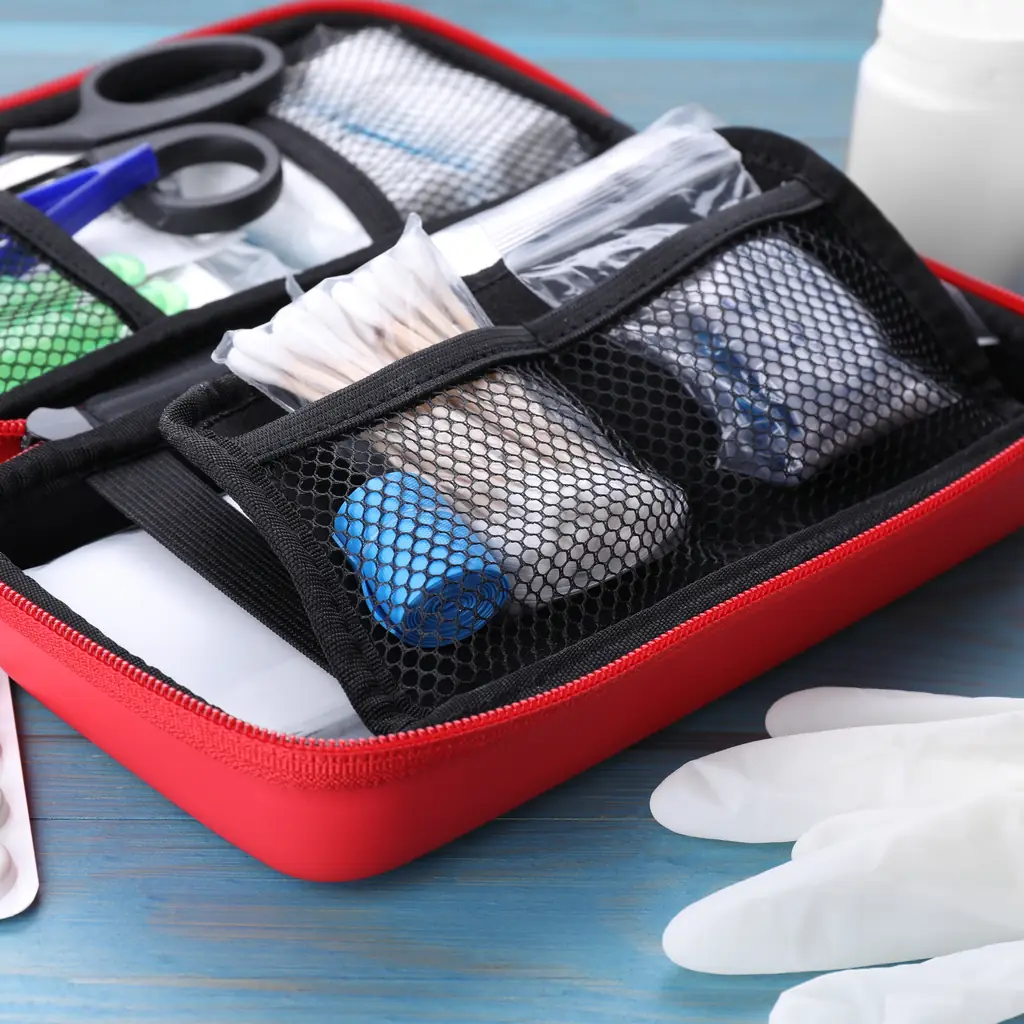An open travel first-aid kit with medicines and supplies