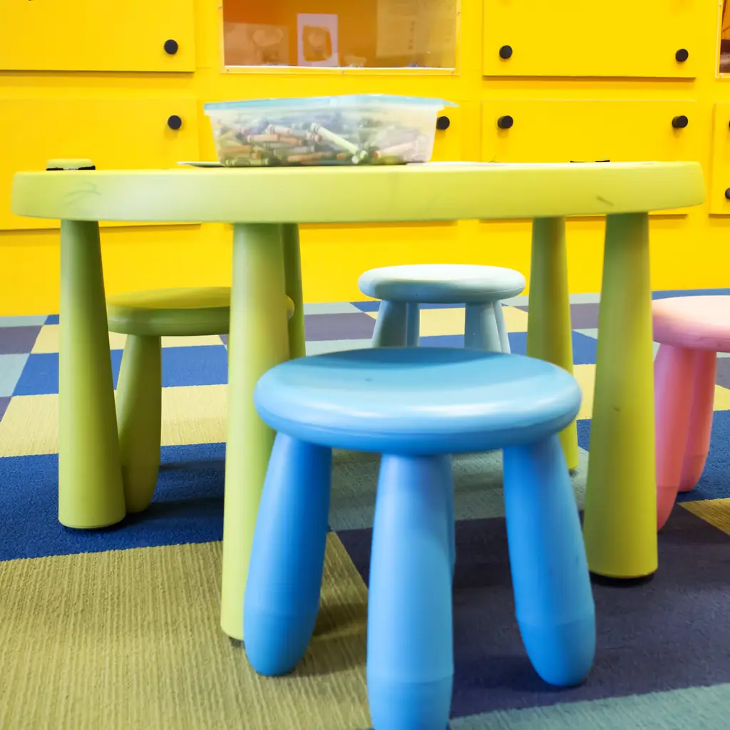 A colorful children's playroom with small tables and stools