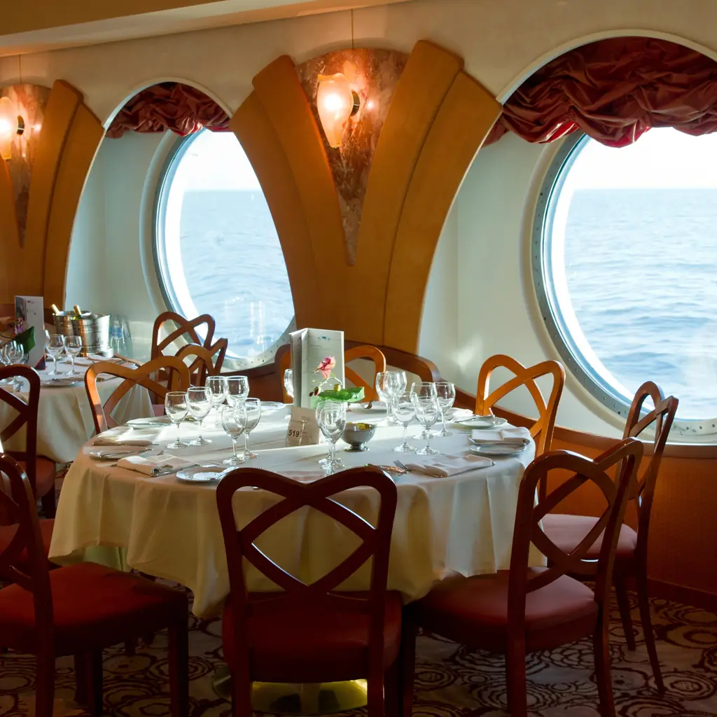 Set tables in an upscale specialty restaurant on a cruise ship at dinner time