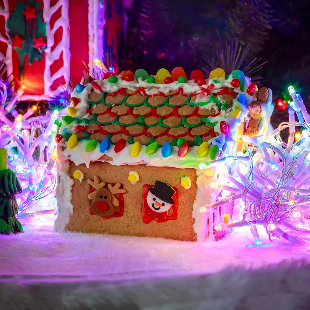 A large gingerbread house holiday display in a lobby