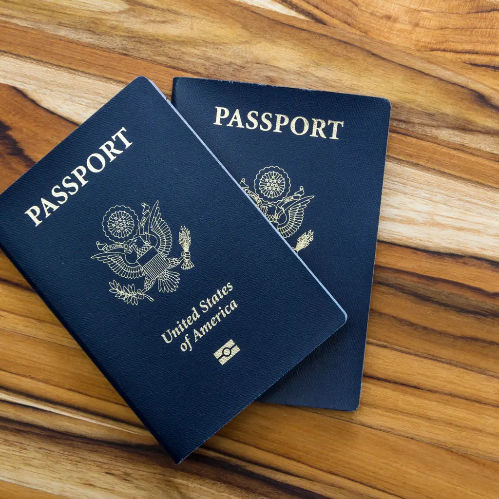 Two US passports on a wooden table before a trip