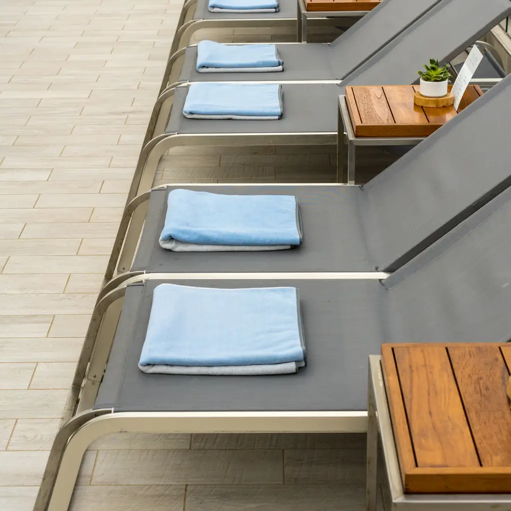 Rows of loungers with folded towels on a quiet deck