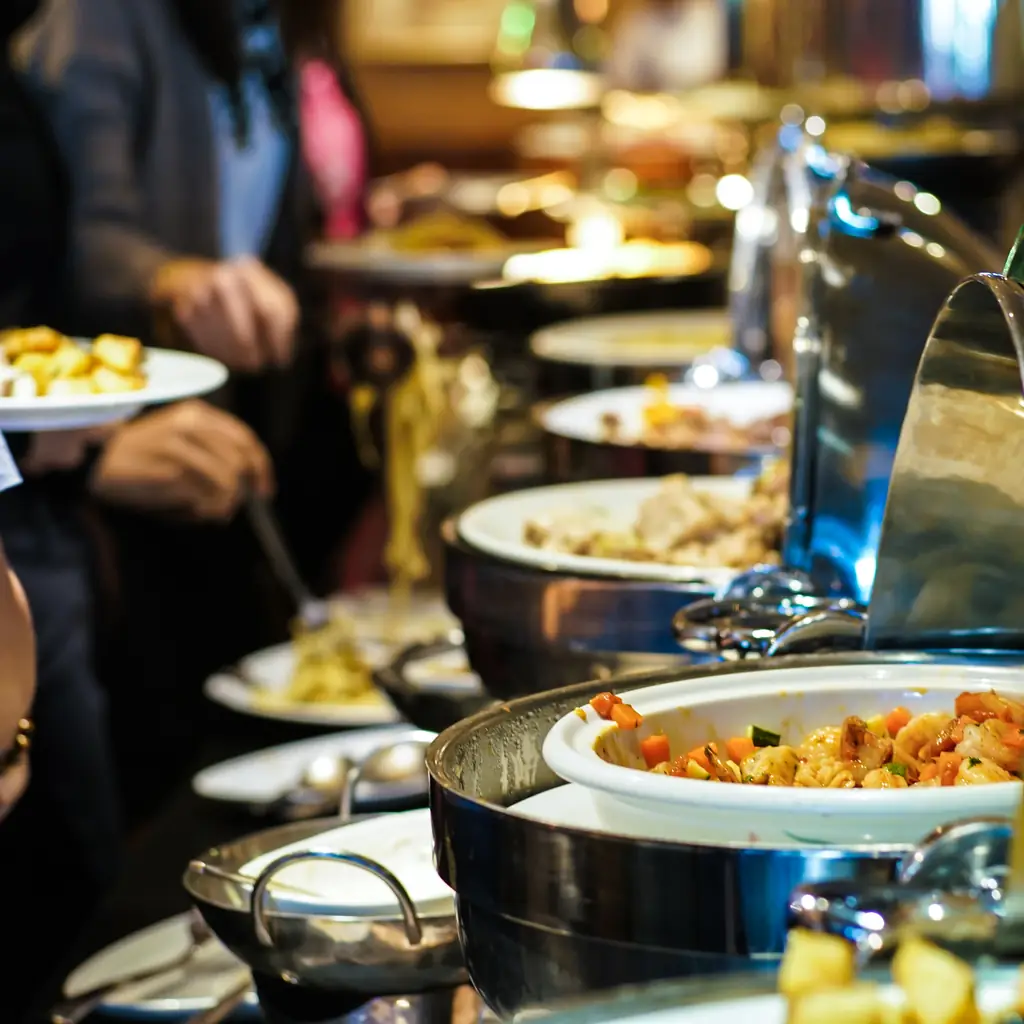 Guests serving themselves from a row of buffet chafing dishes