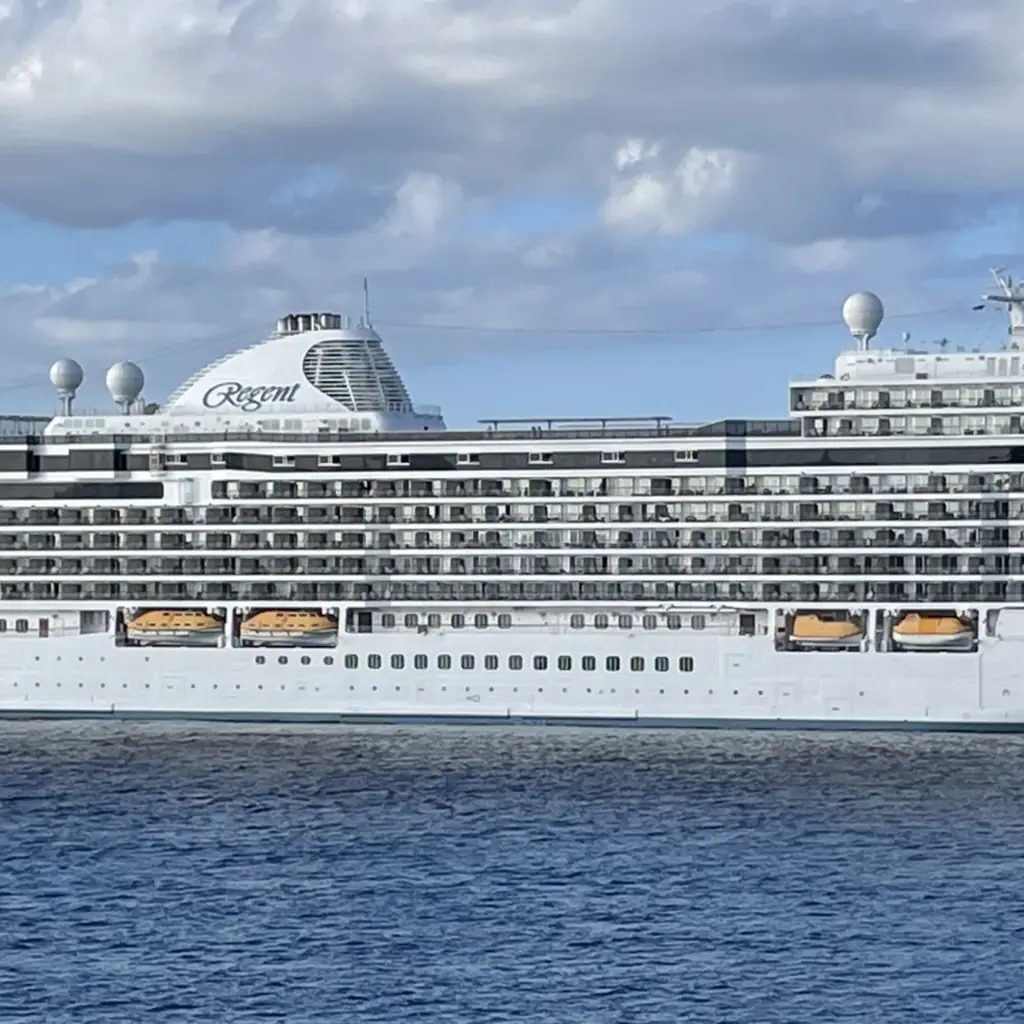 A Regent Seven Seas Cruises ship docked at a port on a clear day