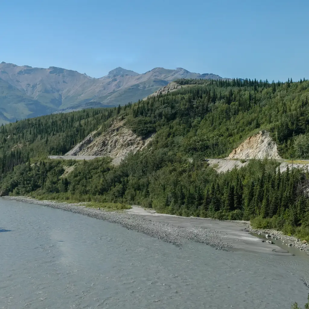 An Alaska Railroad train traveling through a scenic Alaska river valley.