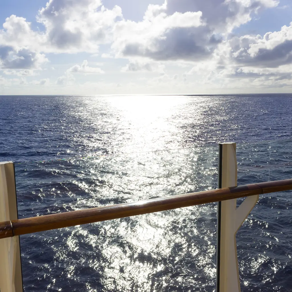 The ocean view from a cruise ship's railing, the kind of open-air access an aft or balcony cabin upgrade adds.
