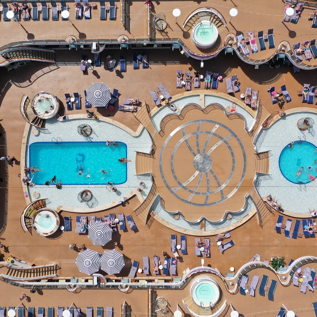 An aerial view of a cruise ship's pool deck and sundeck, showing the kind of upgraded outdoor space available on larger ships.