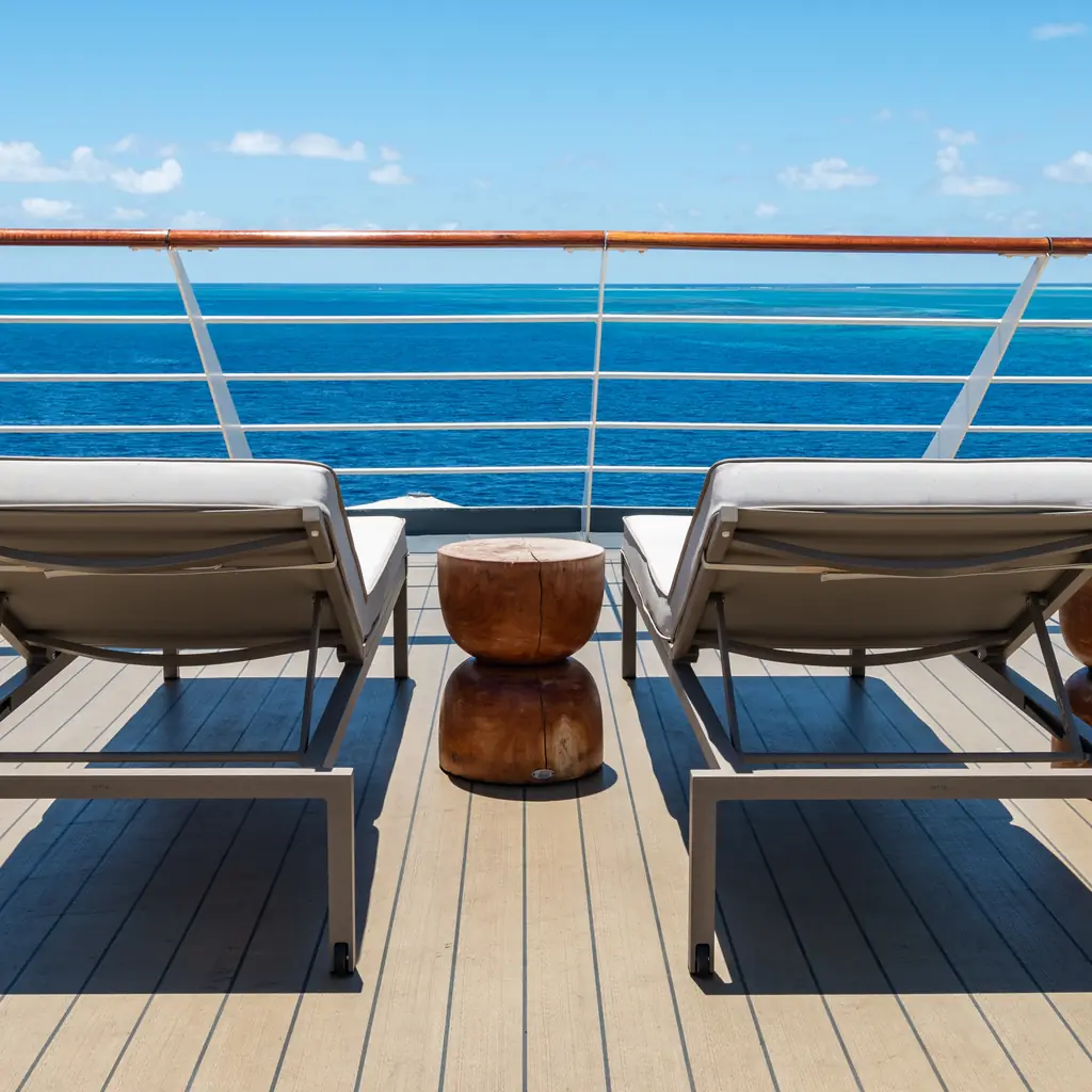 Sun loungers facing the open ocean on a cruise ship deck, the relaxation-focused space near a ship's spa area.