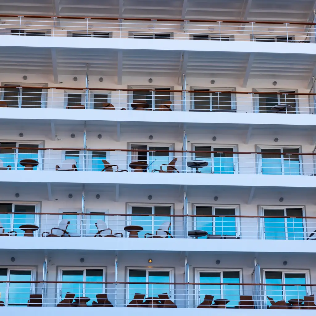 Stacked balcony cabins near the stern of a cruise ship, close to the waterline where engine and thruster vibration is more noticeable.