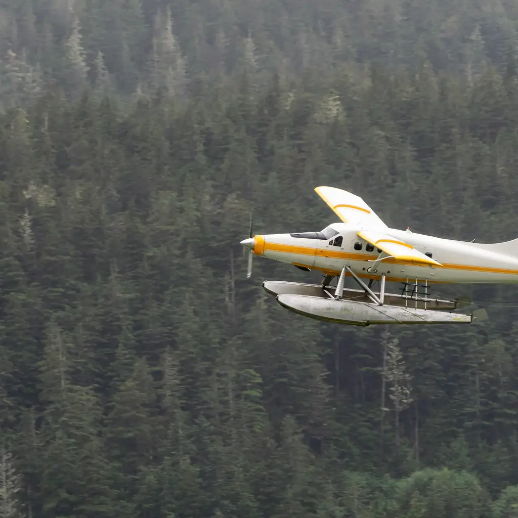 A floatplane flying near Juneau, Alaska, illustrating a scenery-only flightseeing tour rather than a glacier landing.