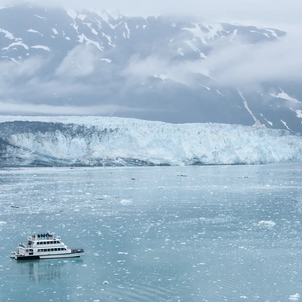 A small day-cruise tour boat approaching a tidewater glacier in Alaska, the kind of pre- or post-cruise glacier day cruise bolted onto a Whittier or Seward sailing.